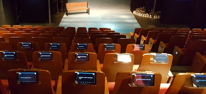 Tablets showing captions in English, simplified Chinese or Japanese are offered to the audience of “Only You” (당신만이) at the JTN Art Hall in Daehangno, Seoul. (Domo Company)